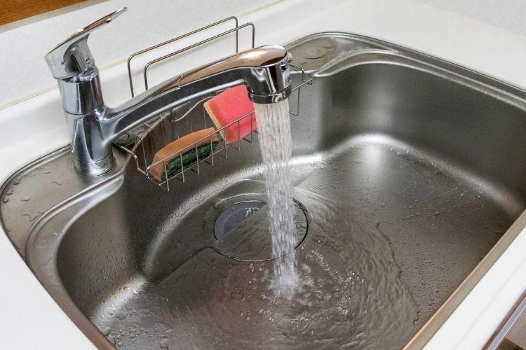 Flowing water in a silver stainless steel sink